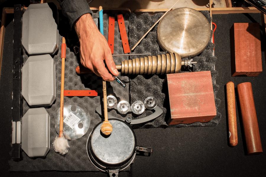 Strumenti a percussione e oggetti sonori disposti sul tappeto